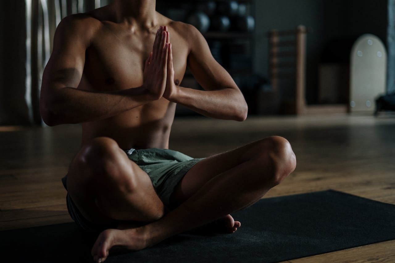 A young man meditates in a yoga studio, promoting relaxation and wellness.
